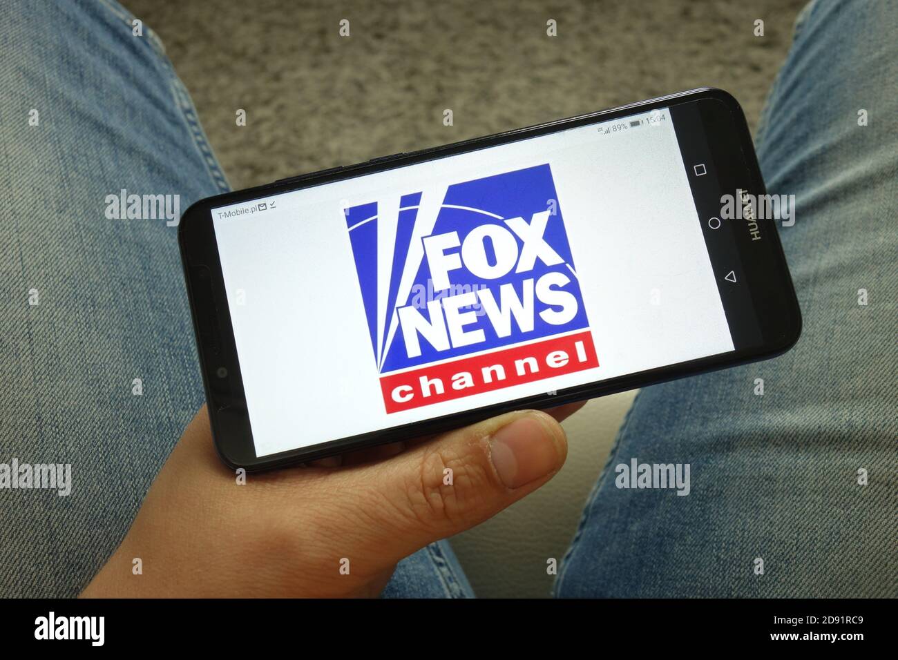 Homme tenant un smartphone avec le logo Fox News Channel Banque D'Images