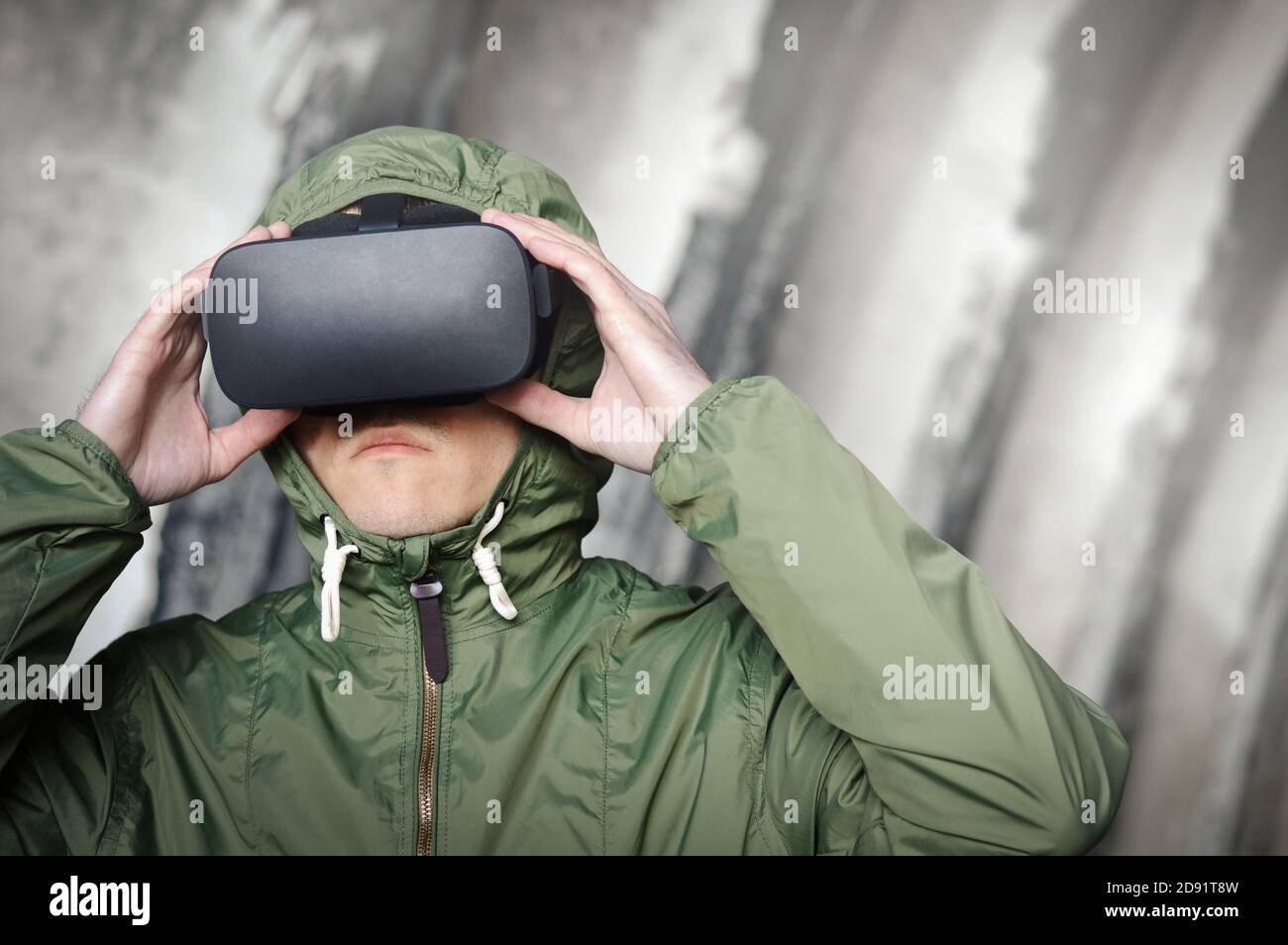 jeune joueur avec un micro-casque de réalité virtuelle dans un environnement vert la veste protectrice teste un jeu de guerre et utilise le meilleur les technologies virtuelles du futur Banque D'Images