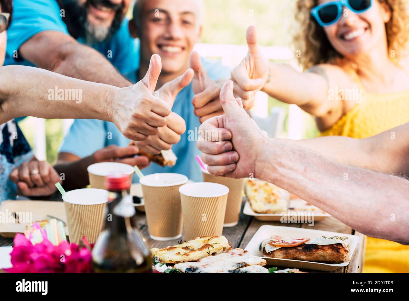 Groupe famille caucasiens les gens célèbrent ensemble avec plaisir et de profiter de la nourriture et des boissons -. Fête d'anniversaire gros plan avec des pouces et rires dans le dos Banque D'Images