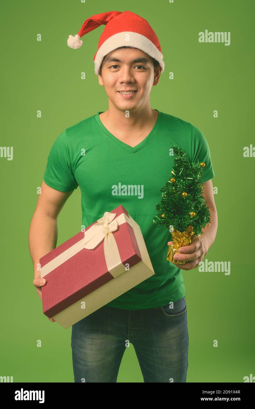 Jeune charmant philippin prêt pour Noël sur fond vert Banque D'Images