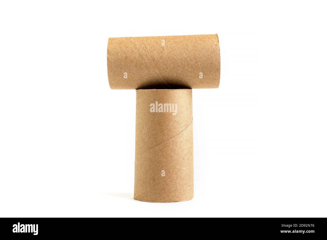 Lettre T de la composition de deux tubes en carton sur fond blanc. Gros plan des rouleaux de toilettes vides Banque D'Images