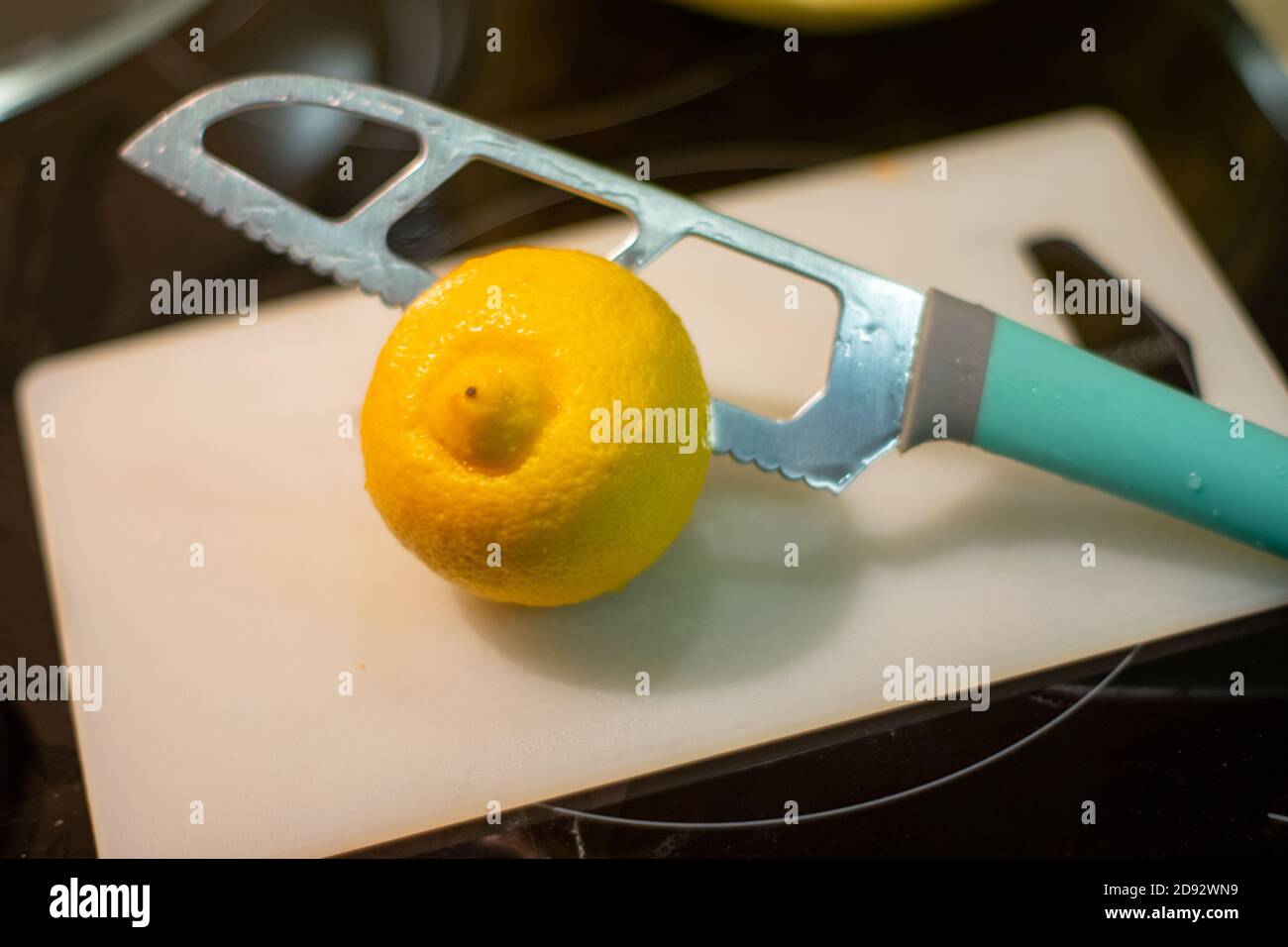 Couper un citron avec un couteau bleu dans le cuisine Banque D'Images