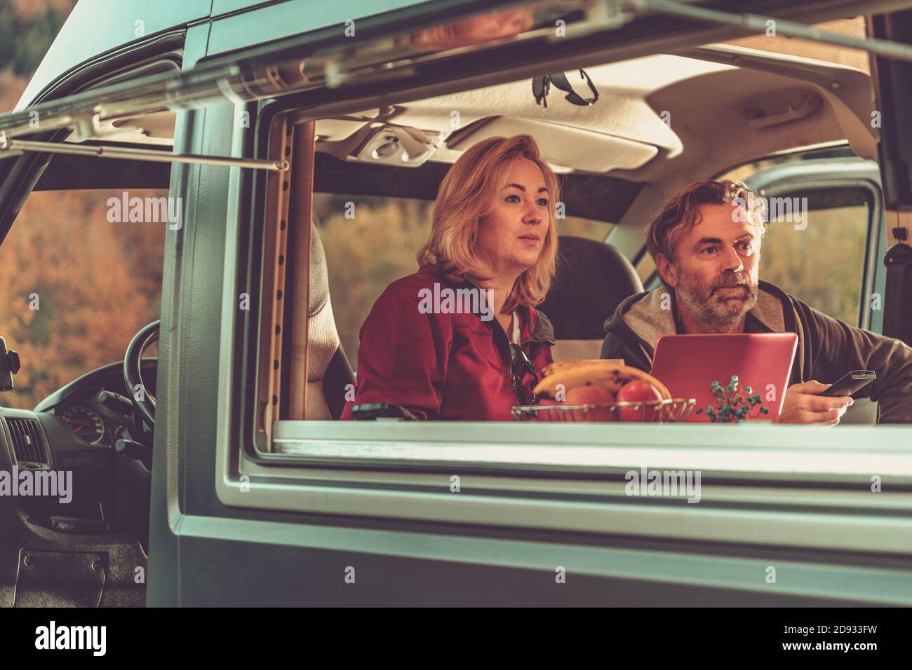 Couple de Caucasiens regardant un jeu de télévision passionnant à l'intérieur d'un camping-car auto-fabriqué Van RV pendant une escapade pittoresque week-end d'automne. Thème Van Life. Banque D'Images