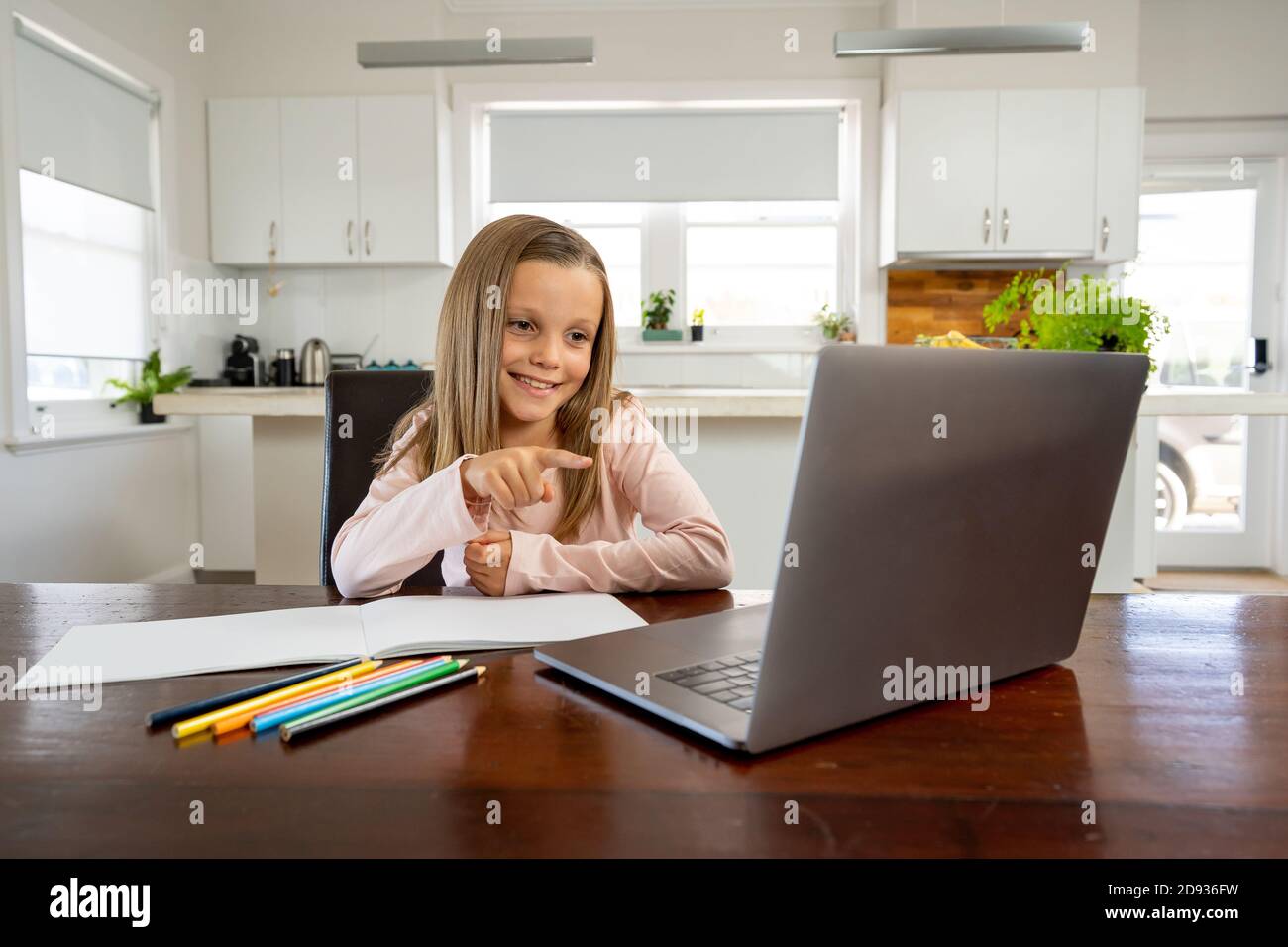 Bonne écolière sur ordinateur portable regardant la leçon en ligne apprendre à distance à la maison dans l'isolement. L'éducation, les quarantaines et les écoles rouvrant ou shuttin Banque D'Images