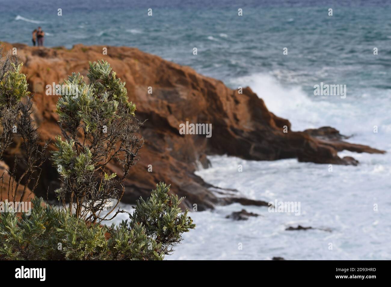 Couple de deux personnes sur une falaise une mer orageux avec des vagues Banque D'Images