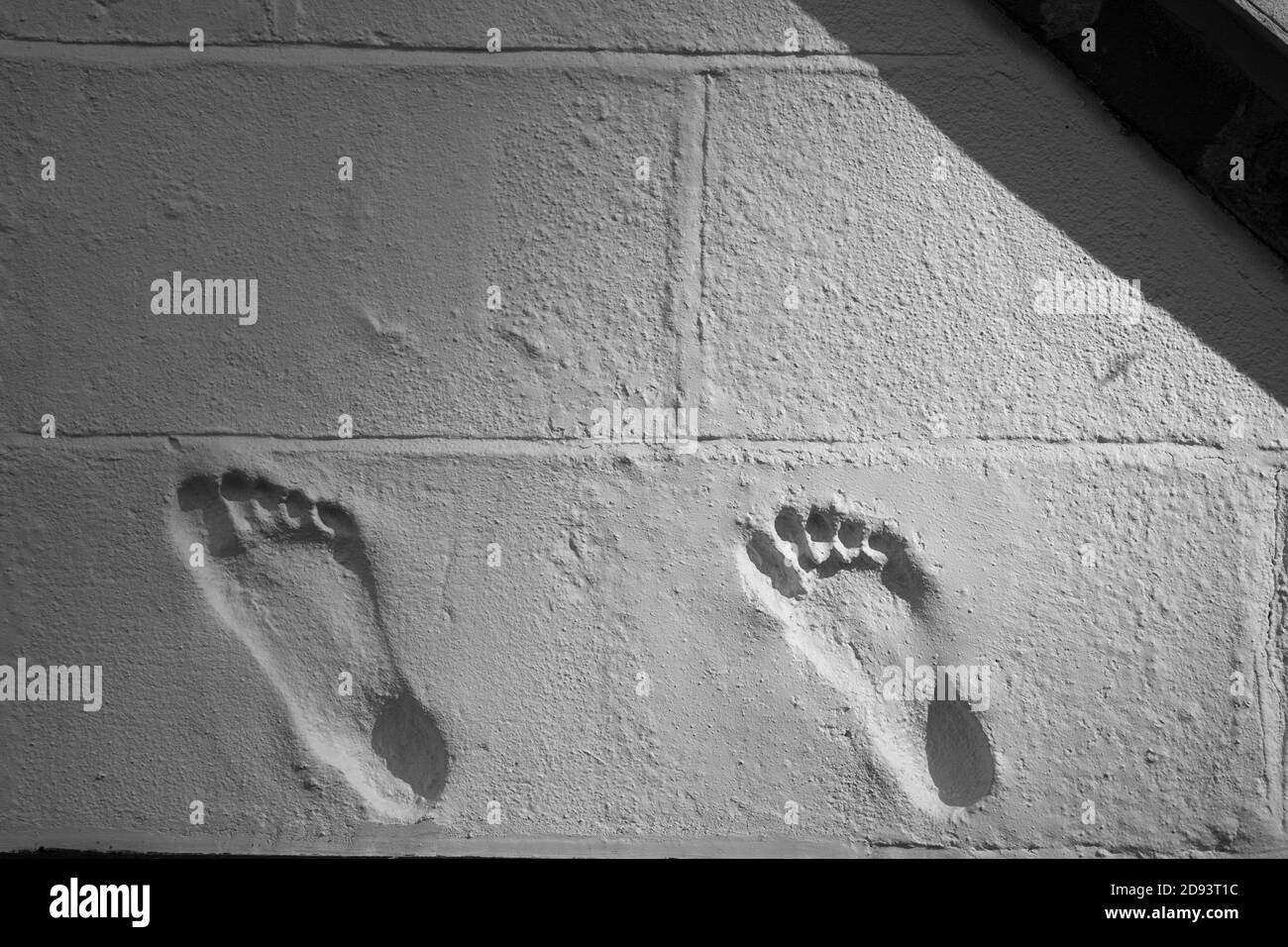 Deux impressions de pieds dans le rendu sur un mur de maison. Peut-être des propriétaires. Banque D'Images