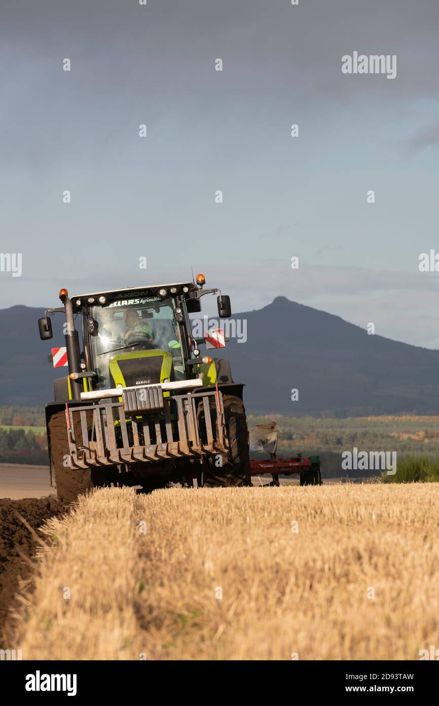 Un tracteur Claas labourant un terrain de chaume sur un sol ensoleillé Après-midi dans le Rural Aberdeenshire Banque D'Images