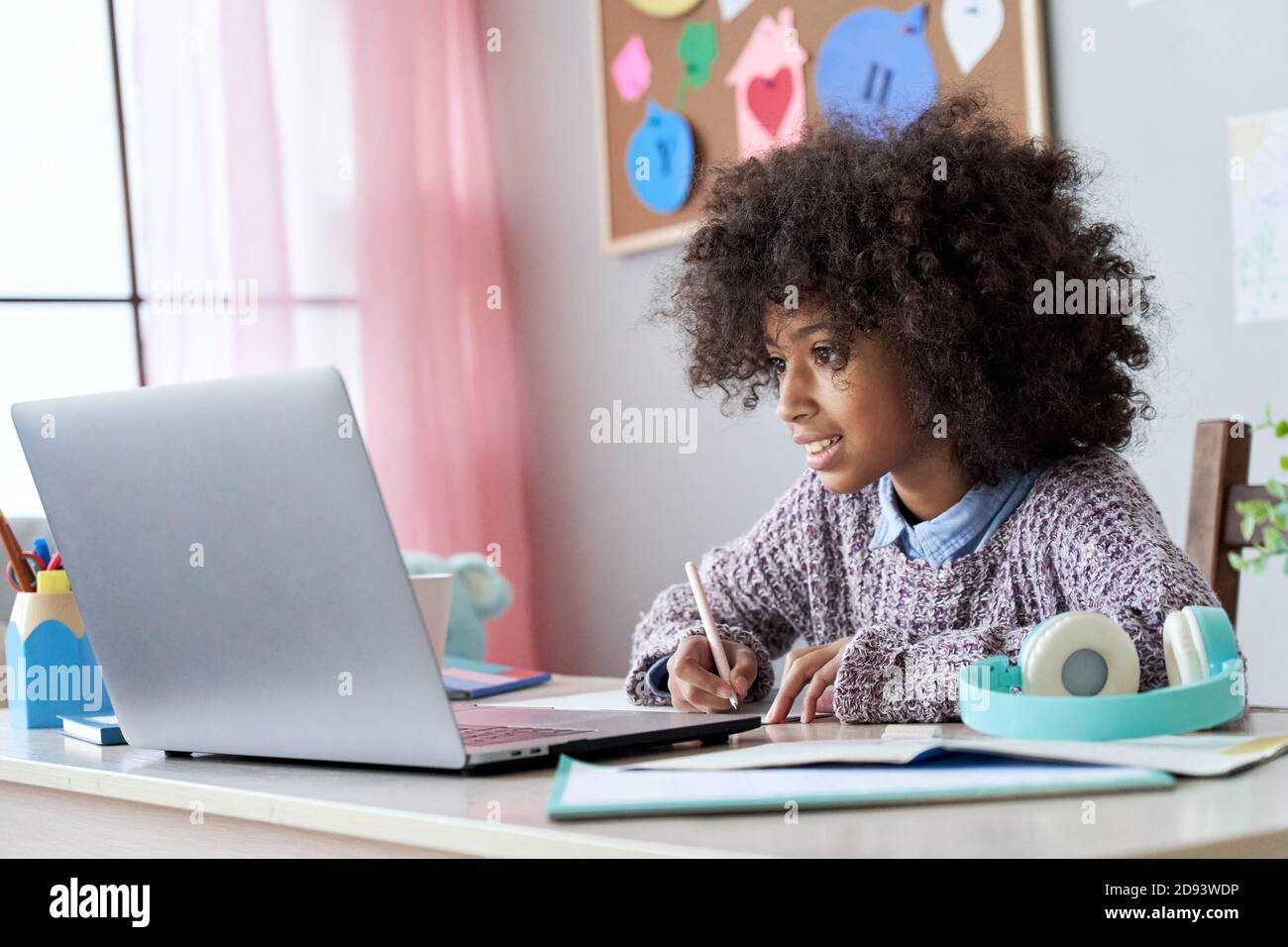 École africaine enfant fille en ligne regarder des cours de vidéo à la maison. Banque D'Images