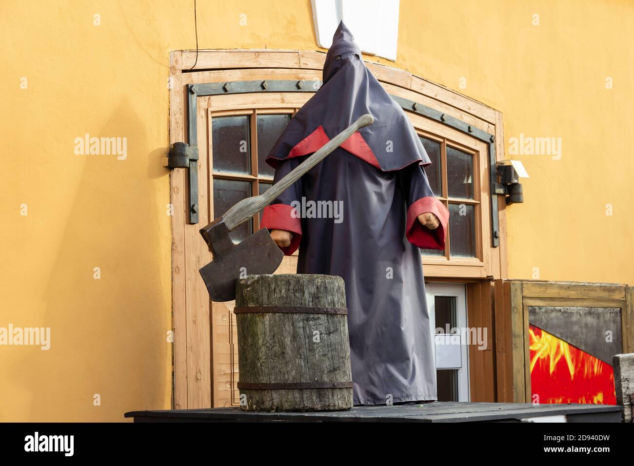 Bourreau médiéval dans un manteau avec une capuche et un bloc de hachage avec une hache sur la plate-forme. Banque D'Images