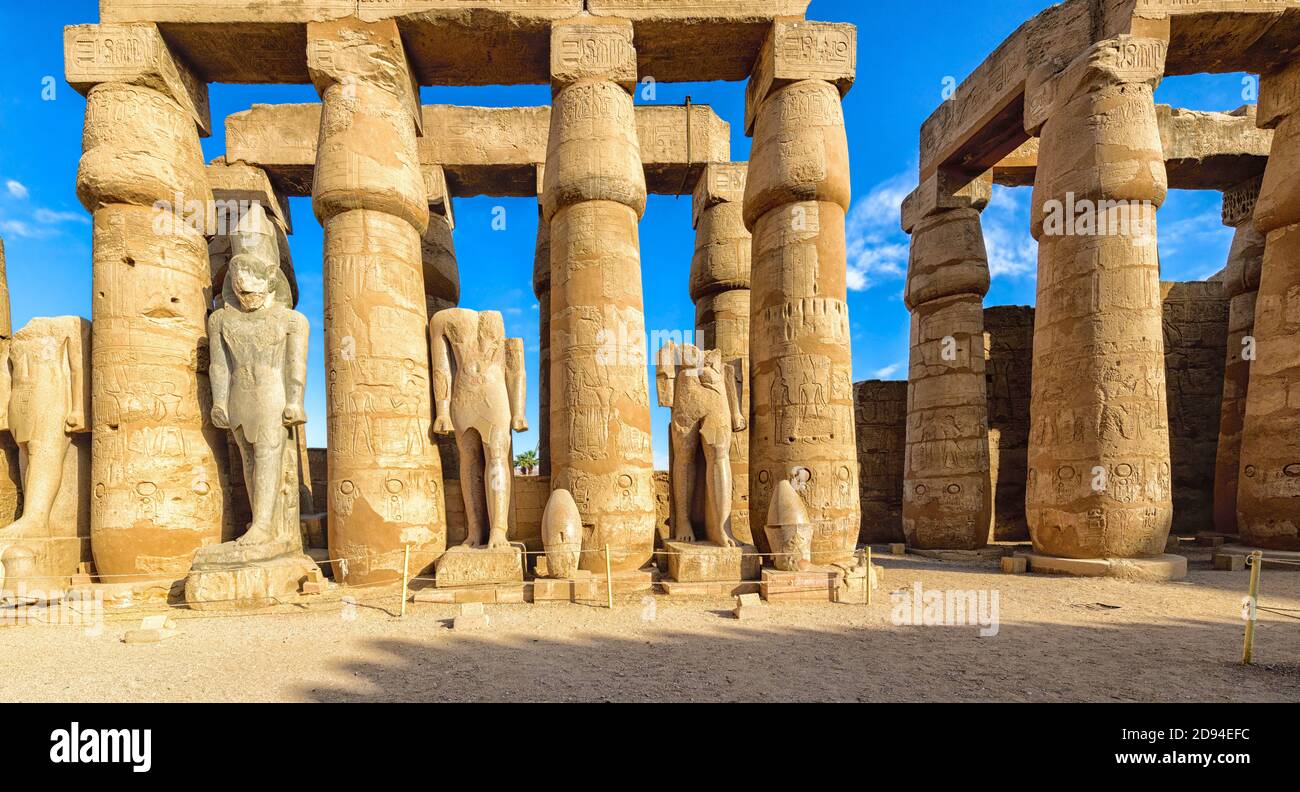 Statues du roi Ramsès II dans la première cour du temple de Louxor. Les couronnes de plusieurs des chiffres sont assises sur le sol à côté d'eux Banque D'Images