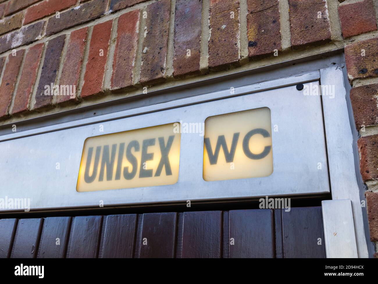 Panneau lumineux au-dessus de l'entrée d'une toilette unisex (neutre en genre) dans le centre-ville de Midhurst, West Sussex, sud-est de l'Angleterre Banque D'Images