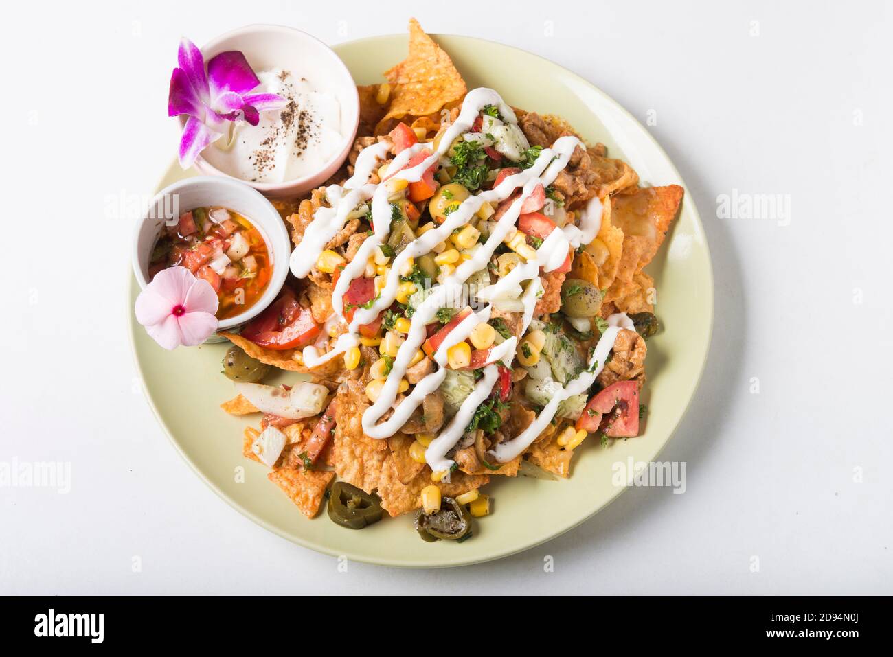 Assiette de nachos au fromage fondu, poulet et olives Banque D'Images