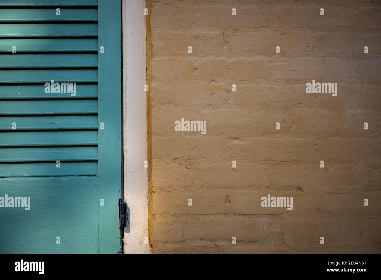 Obturateur sarcelle et fond de mur en brique jaune Banque D'Images