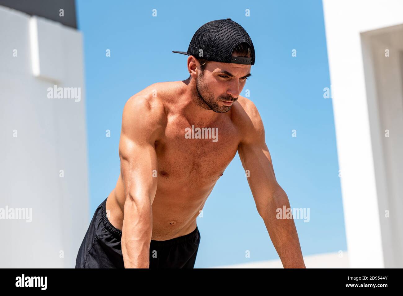 Shirtless handsome masculin bodybuilder faisant pousser vers le haut entraînement à l'extérieur, concept d'exercice à la maison Banque D'Images