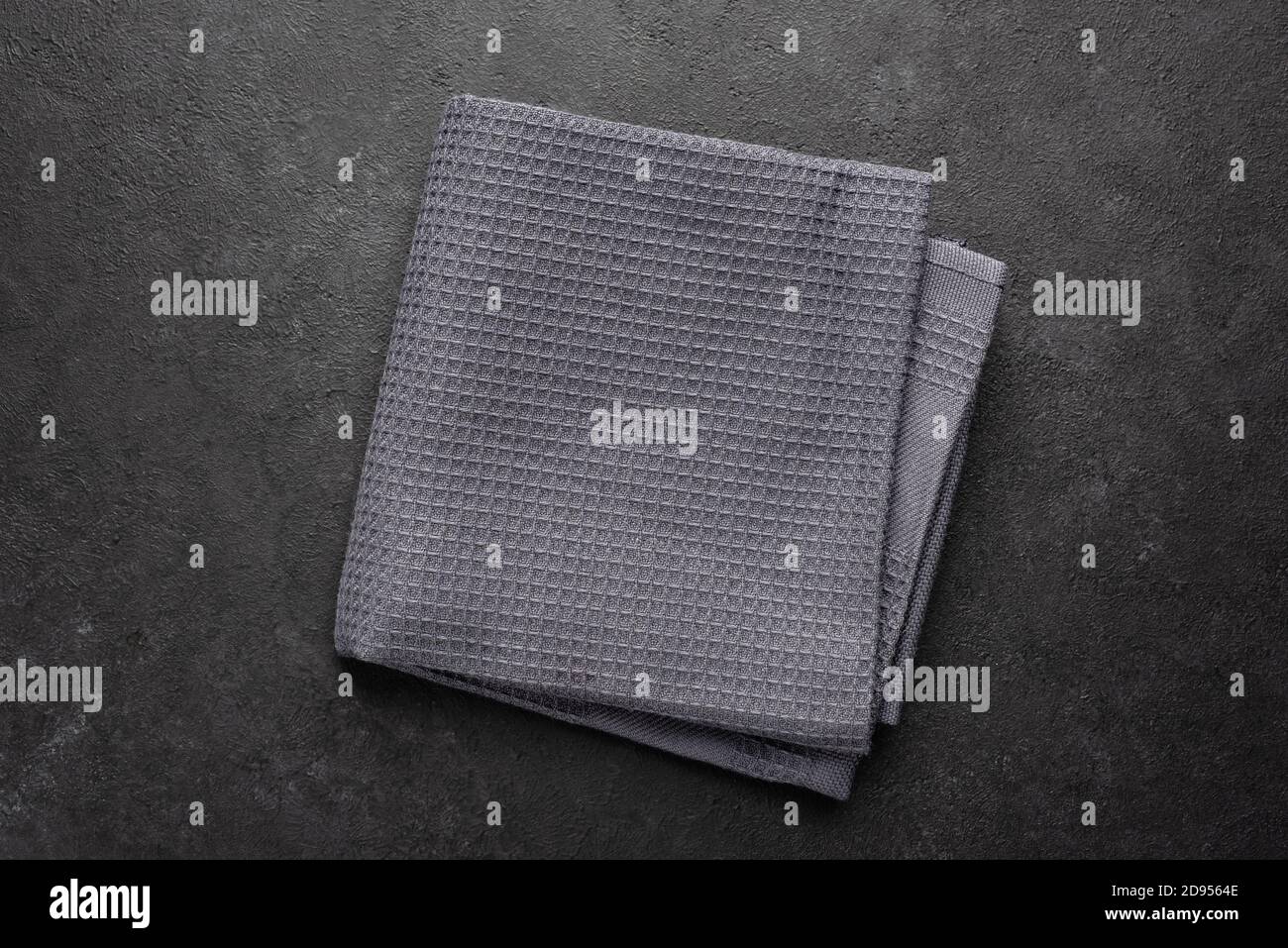 Tissu de cuisine gaufré gris sur fond noir. Vue de dessus. Texture de la serviette de cuisine Banque D'Images
