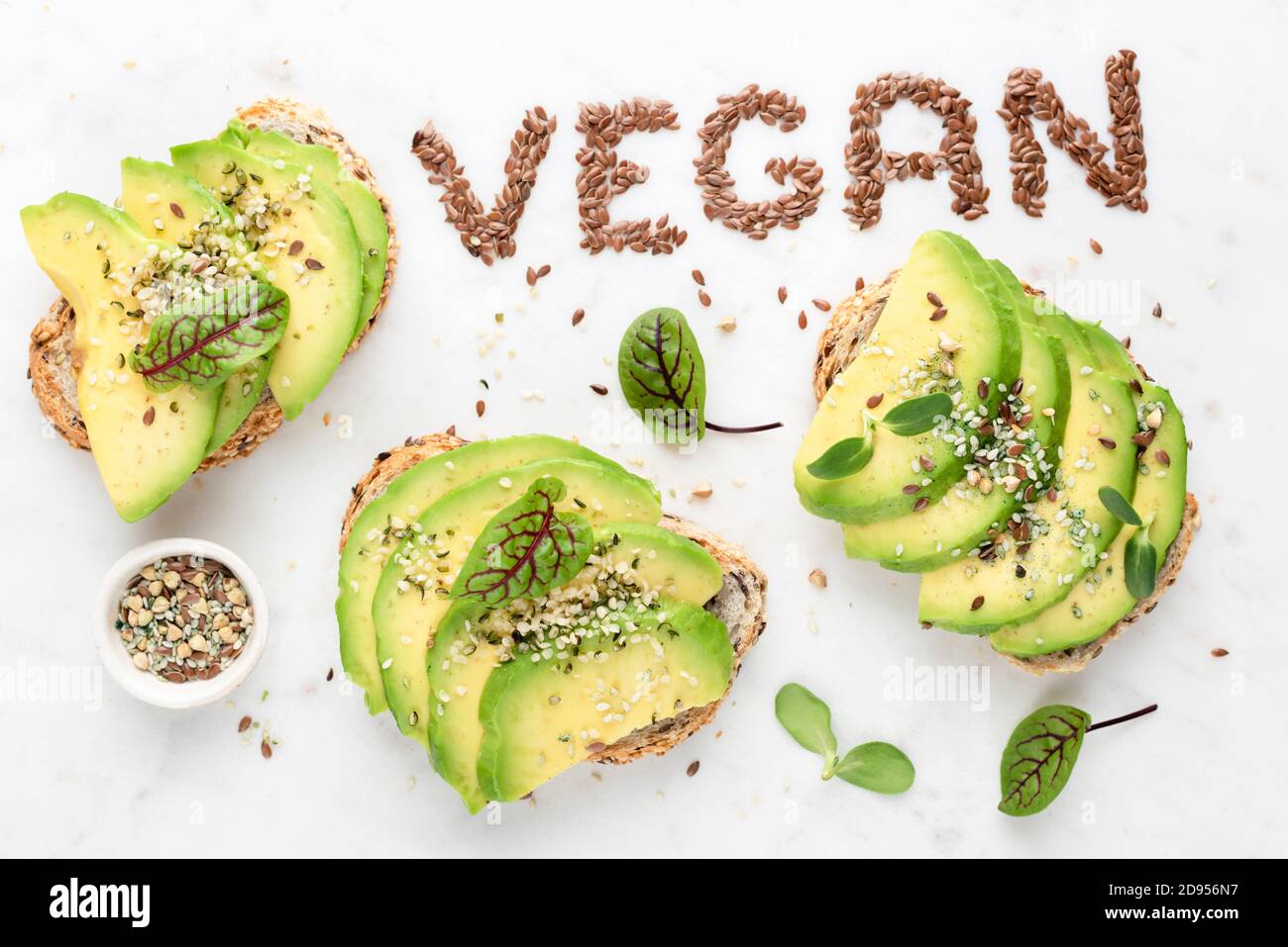 Toast vegan à l'avocat avec graines et pousses de micro-vert. Concept de manger propre, de manger, de manger végétarien végétalien. Vue de dessus Banque D'Images