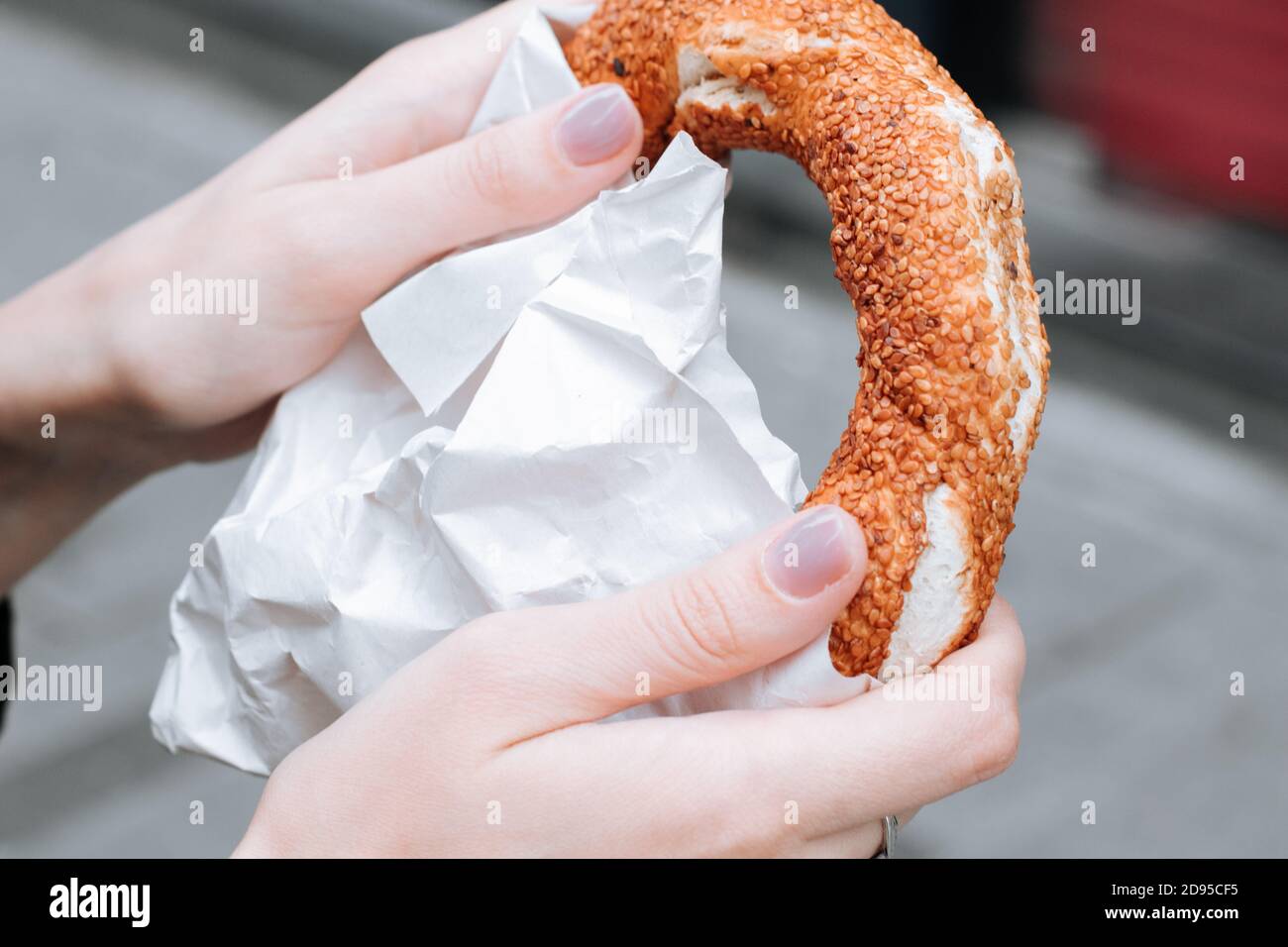 Simit turc traditionnel dans une main féminine. Bagel croustillant aux graines de sésame Banque D'Images