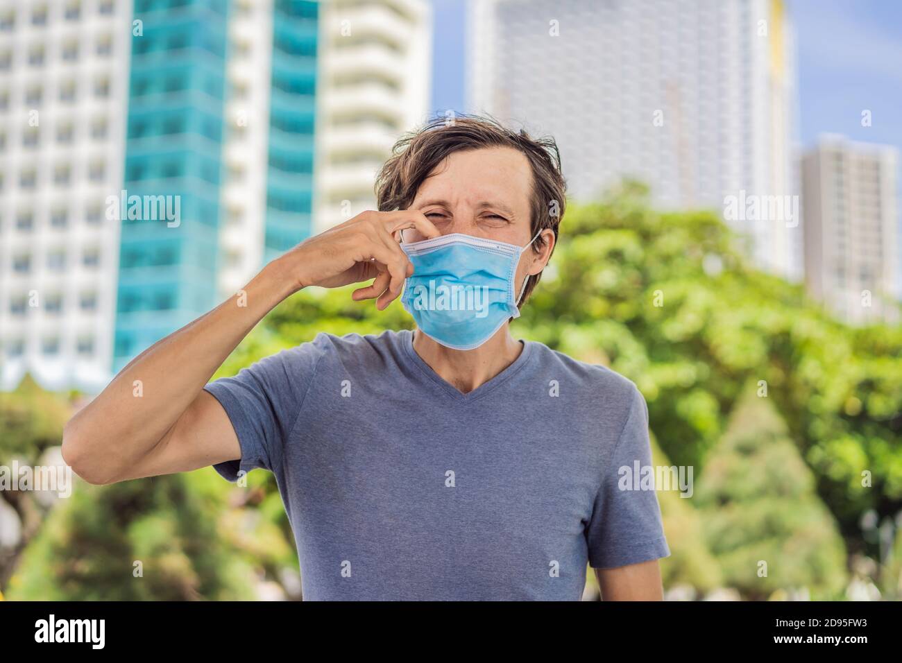 Concept de port incorrect du masque. L'homme se grattant le nez sous le masque, touche le masque Banque D'Images