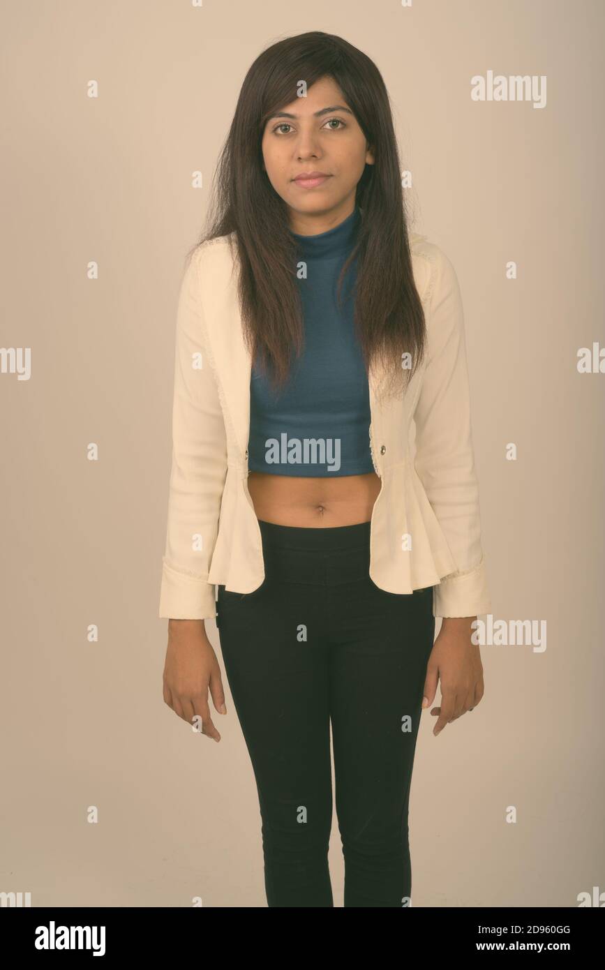 Studio shot of young businesswoman standing Perse contre l'arrière-plan gris Banque D'Images