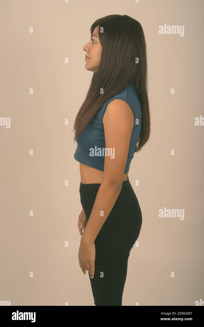 Voir le profil de jeunes Persian woman standing against gray background Banque D'Images