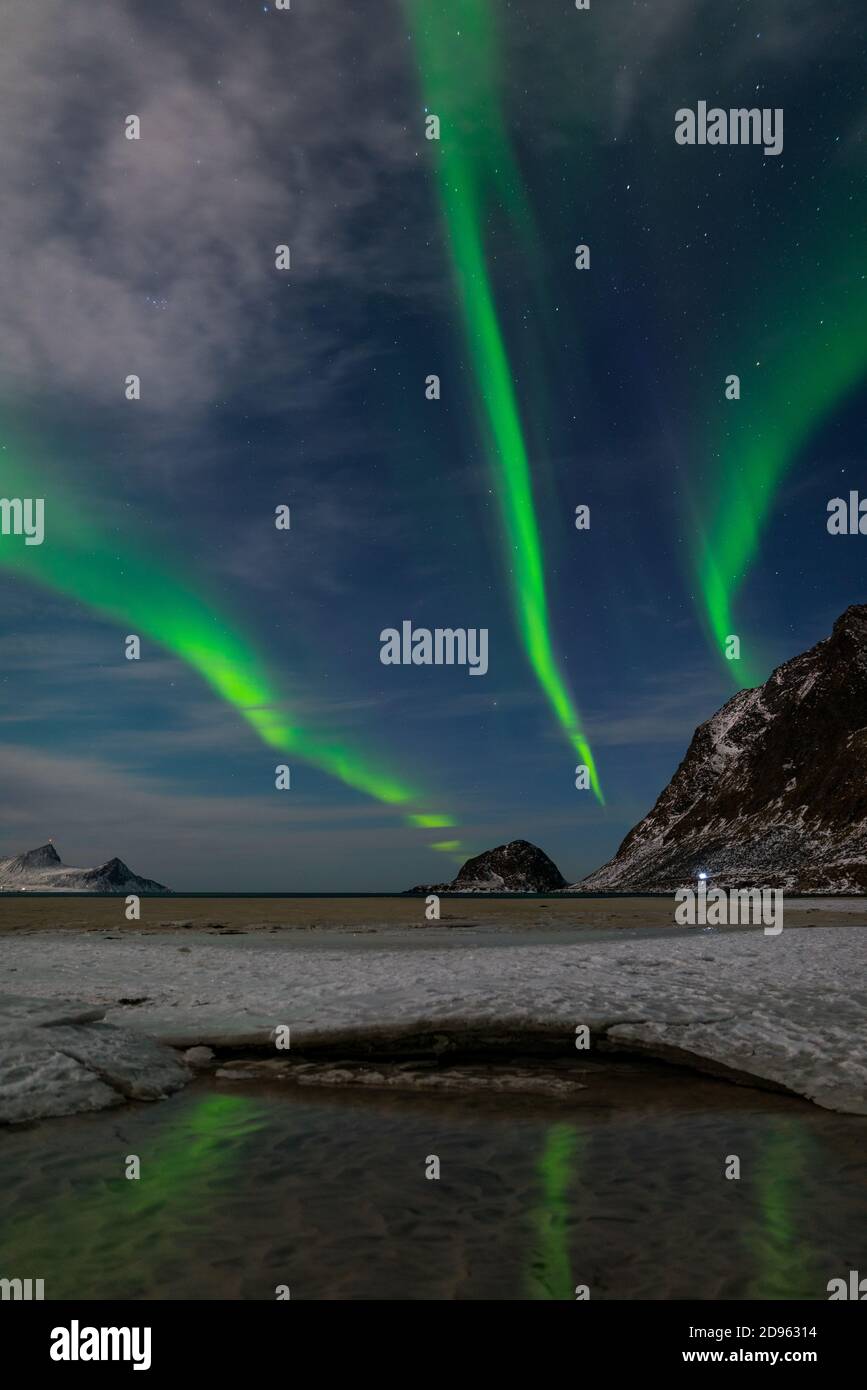 Spectaculaire danse verte forte aurores boréales au cours de la célèbre ronde Plage de sable près de Haukland sur les îles Lofoten en Norvège nuit d'hiver claire Banque D'Images