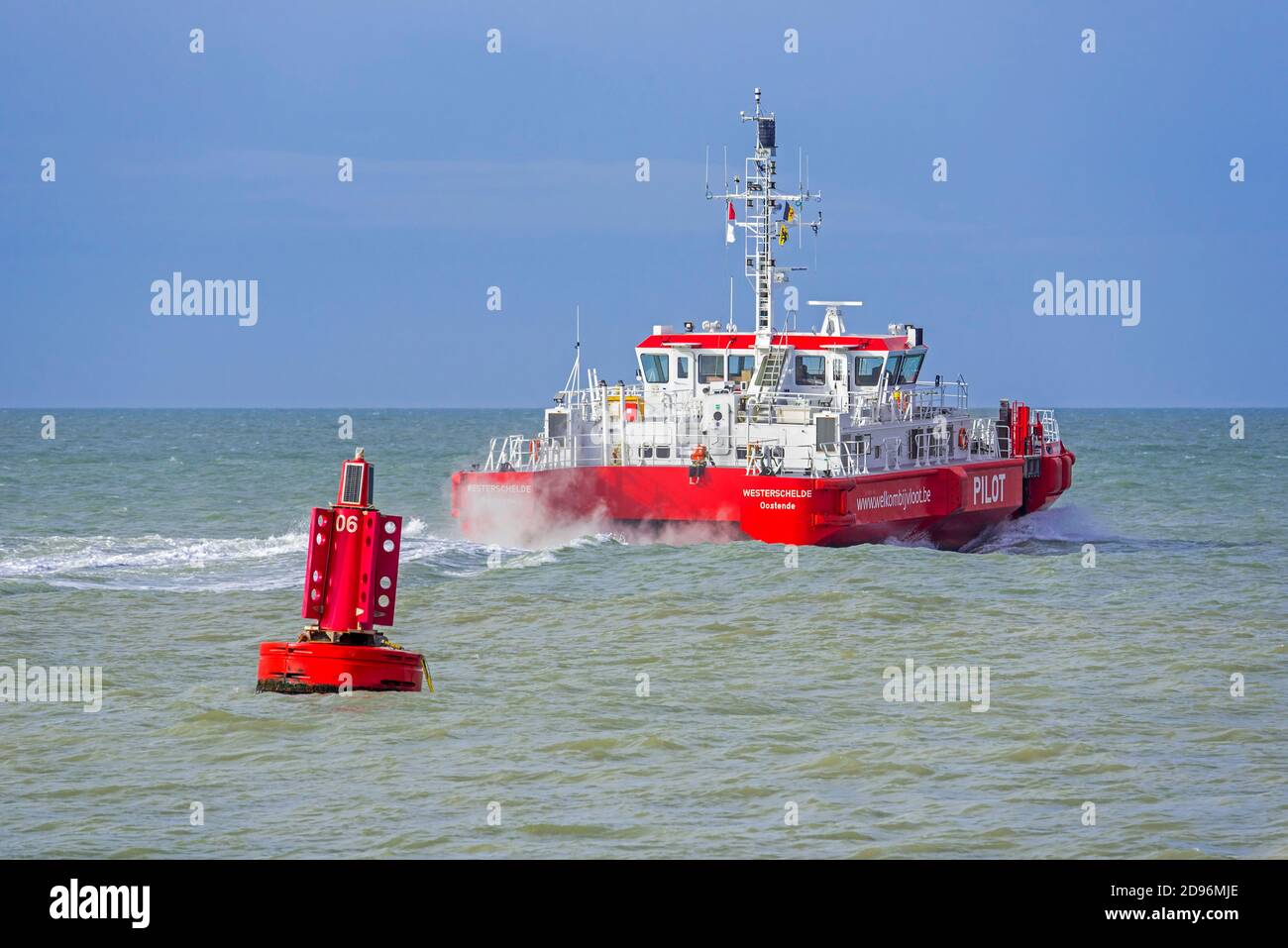 Bouée rouge dans la mer du Nord et le Westerschelde, navire-pilote belge à double coque quittant le port maritime d'Ostende / port d'Ostende, Flandre, Belgique Banque D'Images