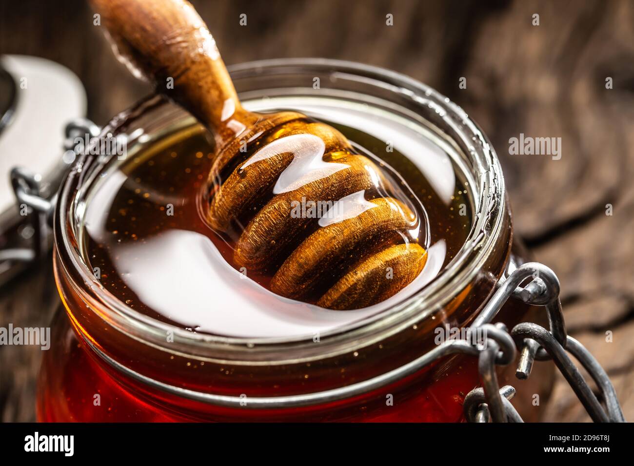 Pot de miel avec un balancier sur une table en bois - gros plan Banque D'Images