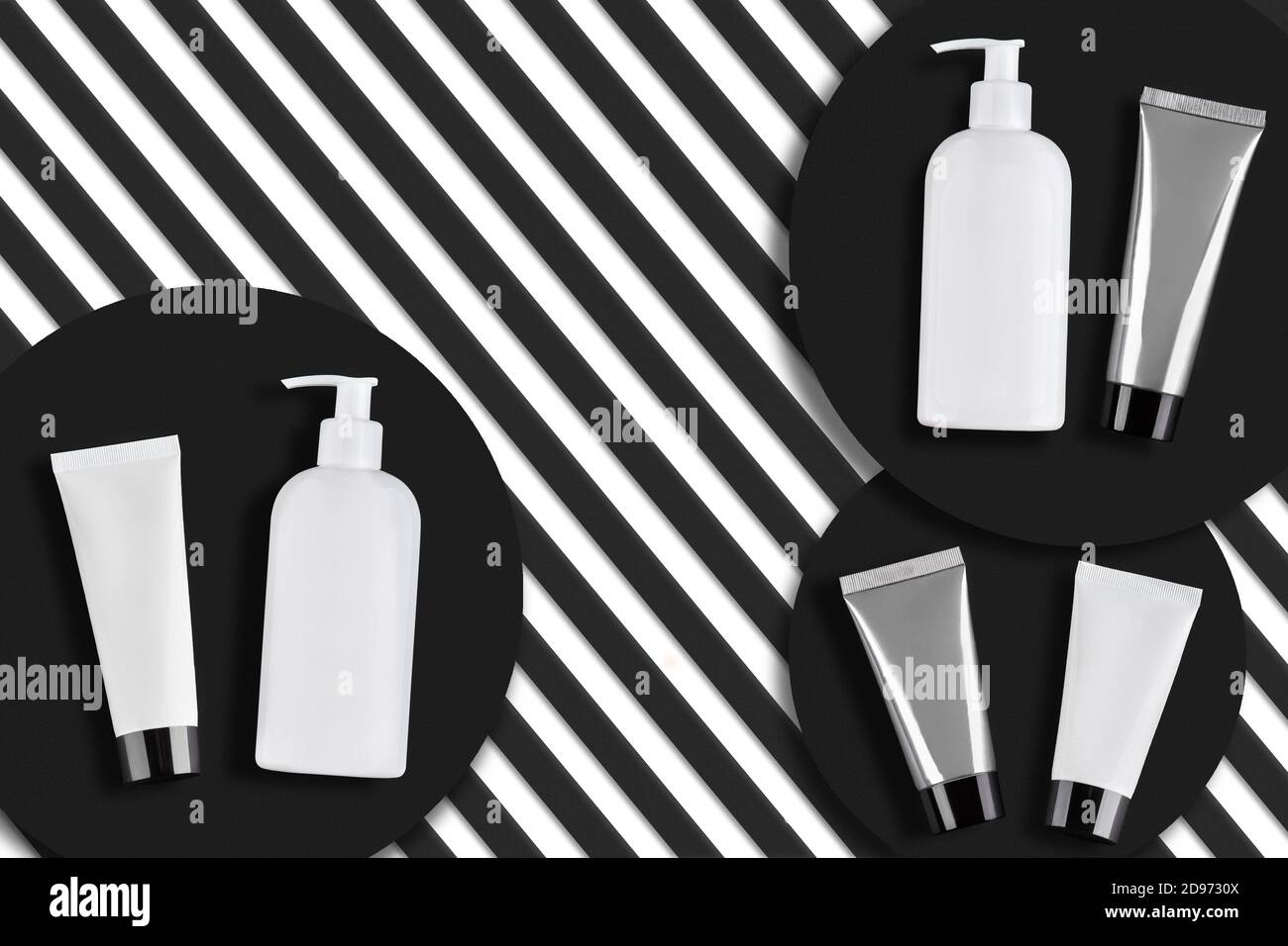 Tubes et flacons à pompe blancs et gris sans logo ni étiquette sur supports ronds noirs, fond rayé. Emballages et contenants de cosmétiques. Gros plan, espace de copie Banque D'Images