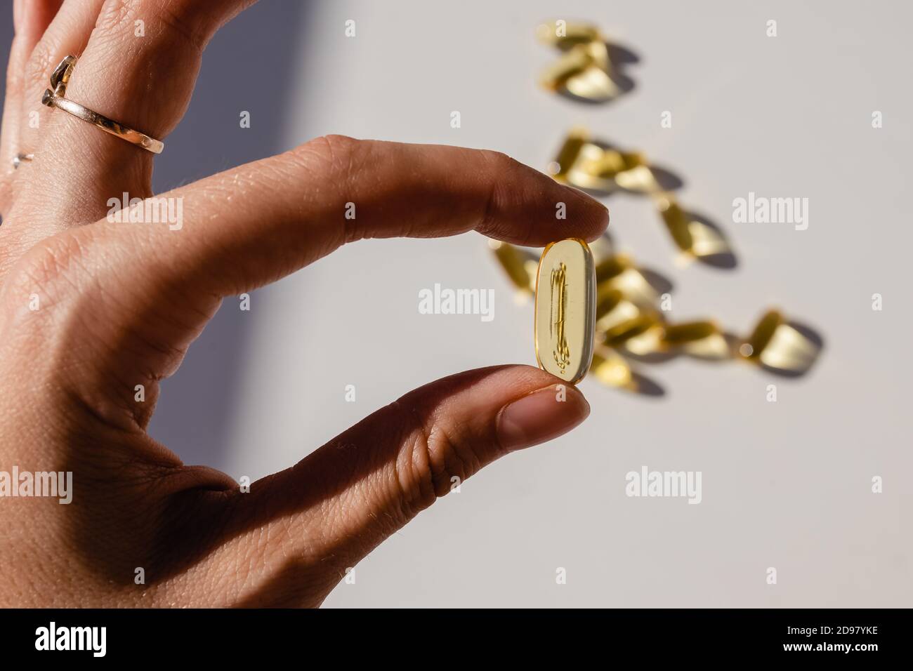 Main féminine tenant la capsule jaune gros plan Banque D'Images