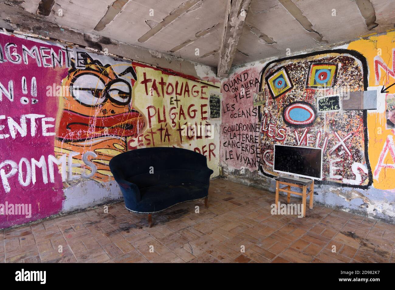 Maison couverte et abandonnée Graffiti intérieur ou salon avec ancien canapé et écran Televisin ou scène Urbex France Banque D'Images