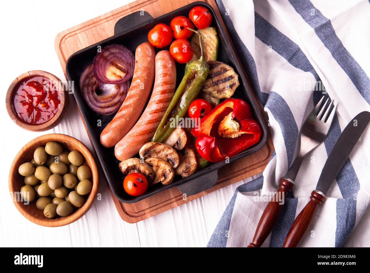 Légumes grillés avec saucisses, tomates, poivrons et champignons sur un barbecue Banque D'Images