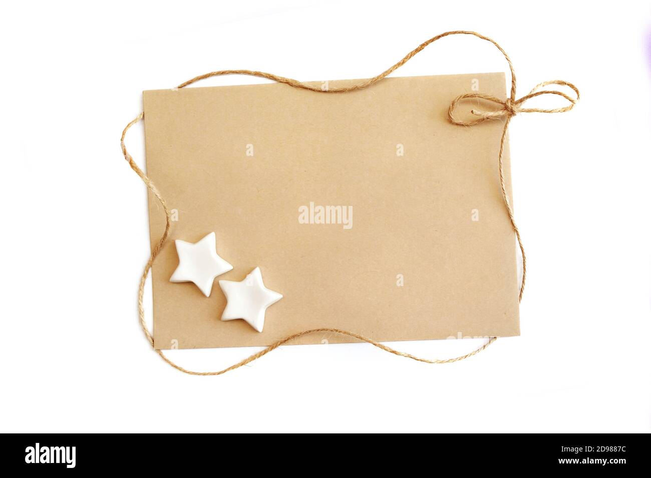 Maquette cadeau de Noël modèle carte de voeux avec feuille de papier kraft et corde sur le cadre sur un fond blanc et place pour le texte. CopySpace Banque D'Images