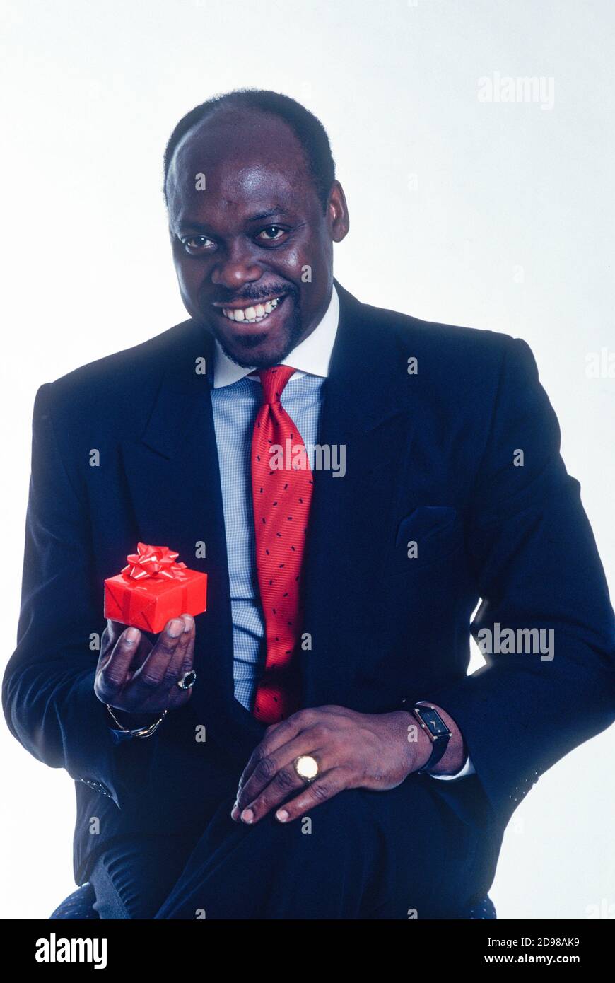 Portrait d'un beau homme d'affaires afro-américain mature, souriant et offrant un présent, USA Banque D'Images
