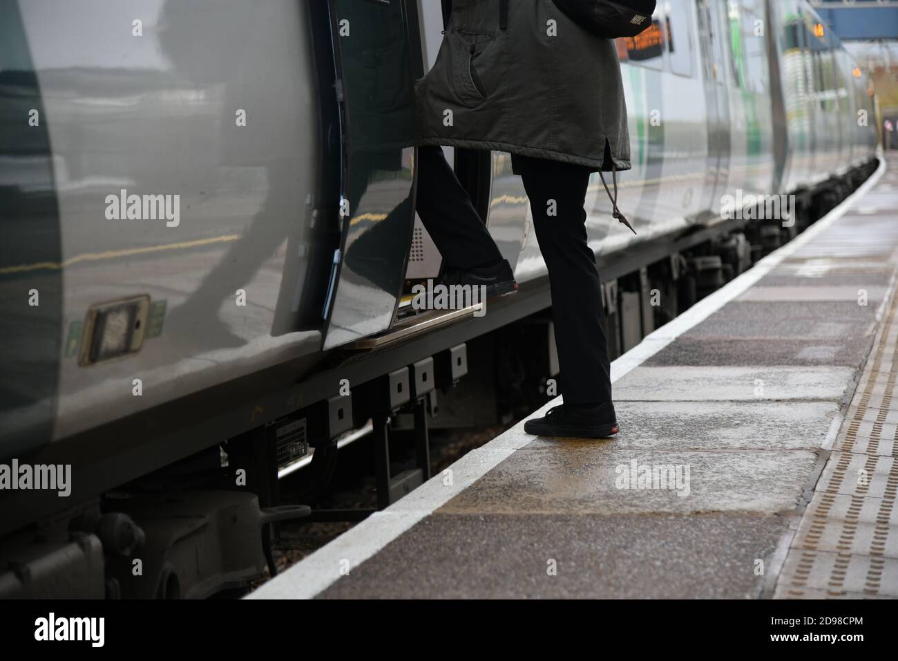 Personne embarquant dans un train au Royaume-Uni montrant l'interface train de la plate-forme avec une distance de marche élevée sur une plate-forme courbe Banque D'Images
