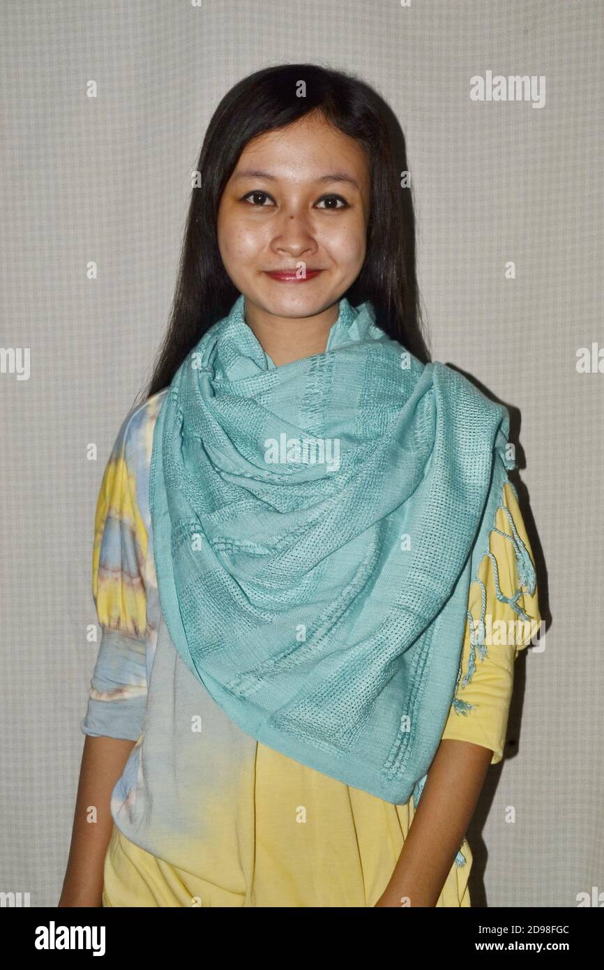 Belles femmes d'Asie du Sud-est portant des chemises à teinture par cravate aux couleurs magnifiques, sourires doux, peu focalisées et bruit d'image Banque D'Images