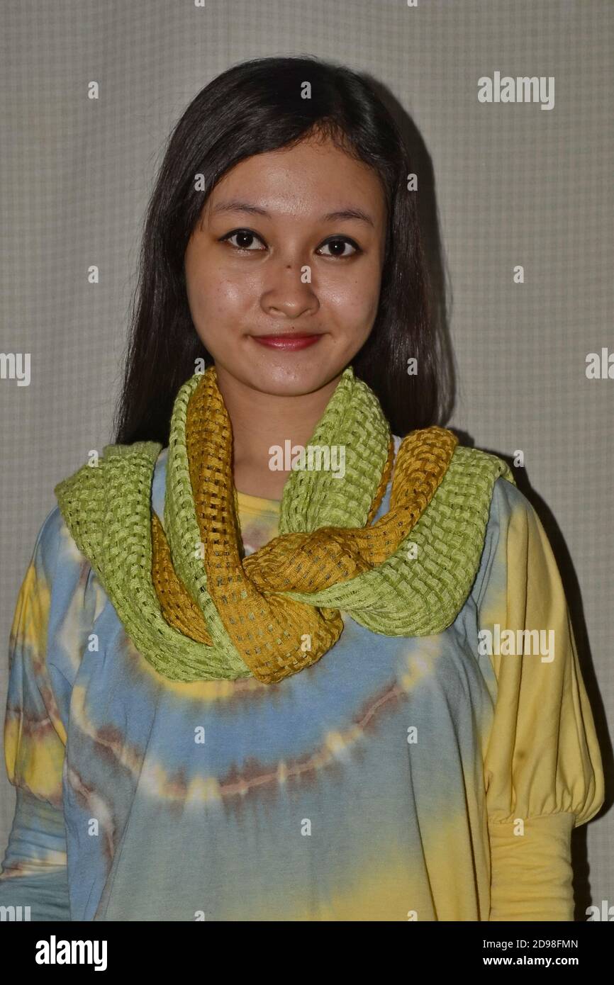 Belles femmes d'Asie du Sud-est portant des chemises à teinture par cravate aux couleurs magnifiques, sourires doux, peu focalisées et bruit d'image Banque D'Images
