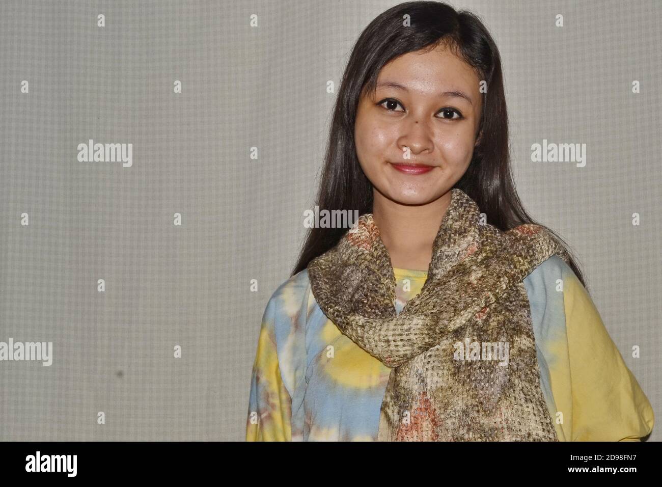 Belles femmes d'Asie du Sud-est portant des chemises à teinture par cravate aux couleurs magnifiques, sourires doux, peu focalisées et bruit d'image Banque D'Images