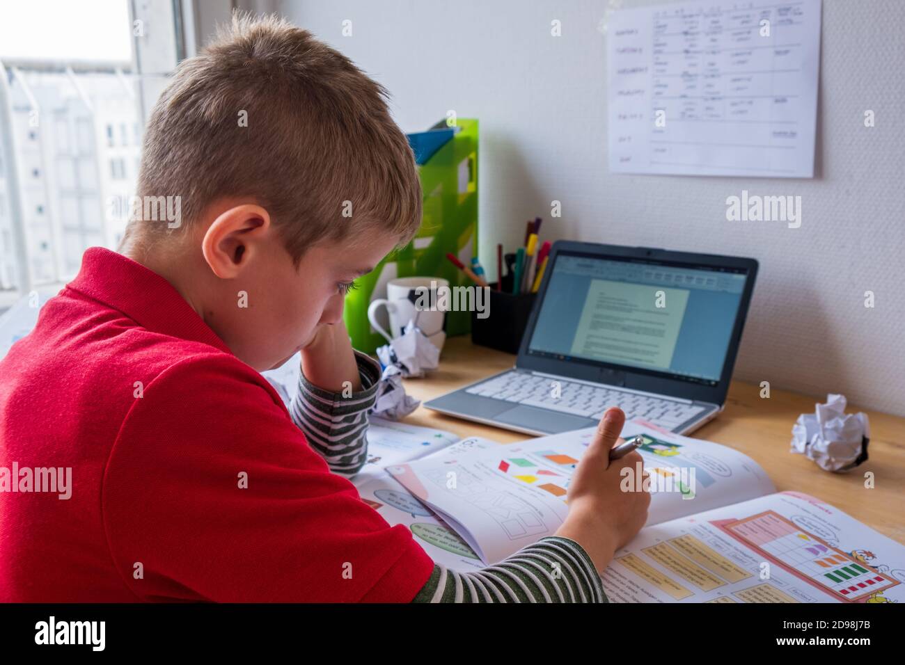 Garçon se concentrant pendant le homeschooling dans le verrouillage de corona Banque D'Images