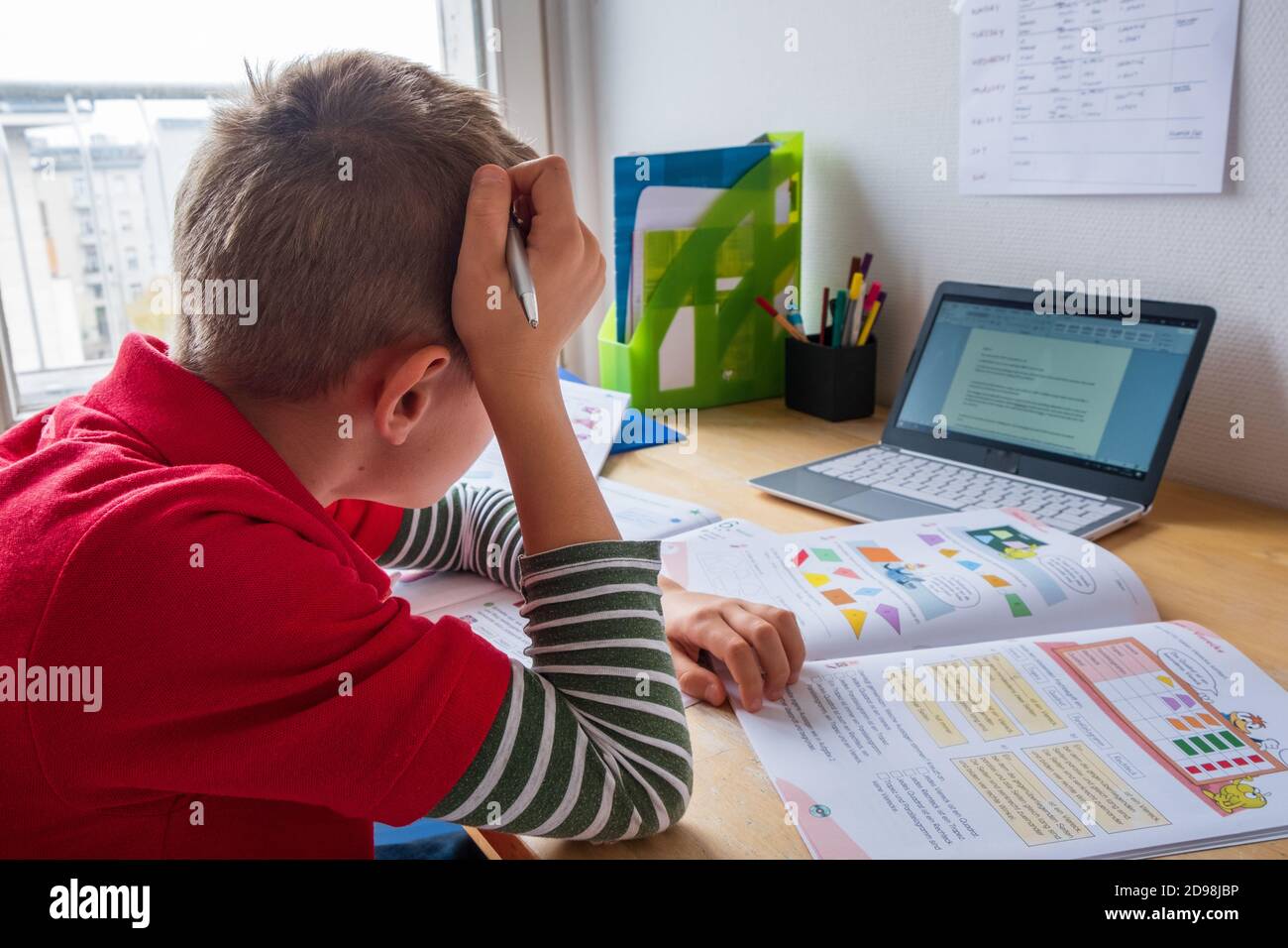 Garçon qui a l'air s'ennuyer pendant qu'il se sent chez soi pendant le verrouillage de la couronne Banque D'Images