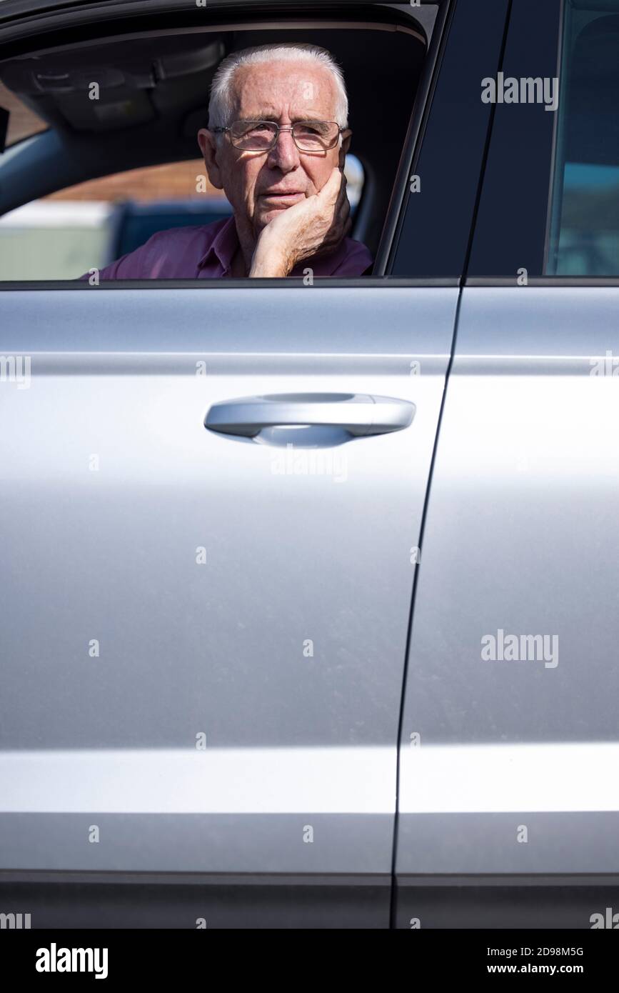 Inquiet conducteur de voiture de premier rang regardant hors de la fenêtre de voiture Banque D'Images