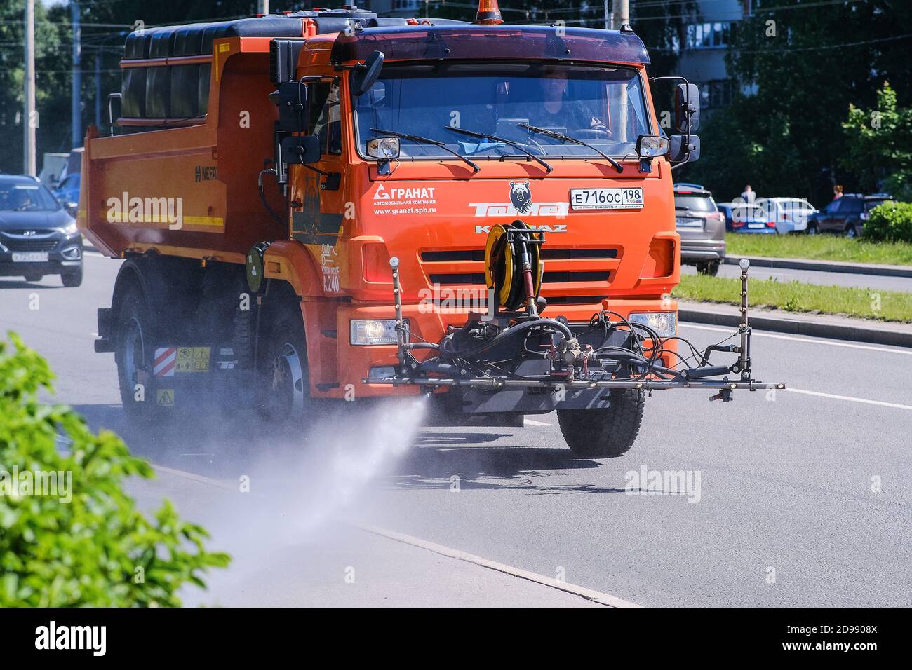 Machine à arroser. Un puissant jet d'eau est dirigé vers le trottoir. Le chariot se déplace pour laver la surface de la route Banque D'Images