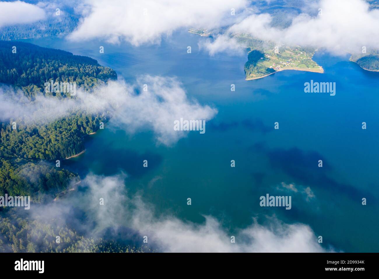 Drone survolant lac de montagne d'été, forêt de pins et lac vert avec des nuages bas, lac Bicaz dans les Carpates roumains. Banque D'Images