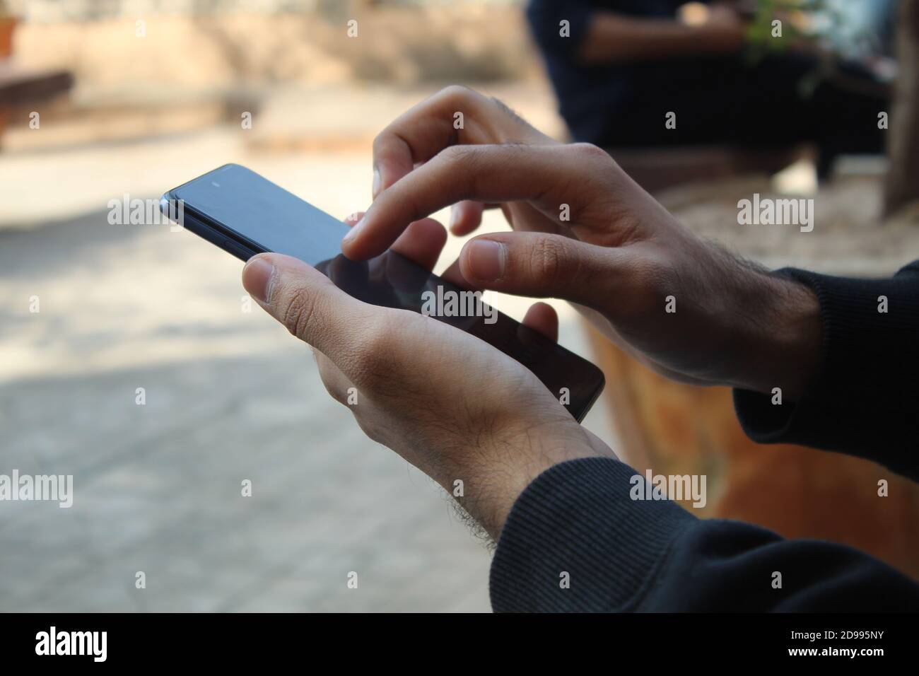 Gros plan des mains de l'homme à peau sombre d'âge moyen utilisant android pone Banque D'Images