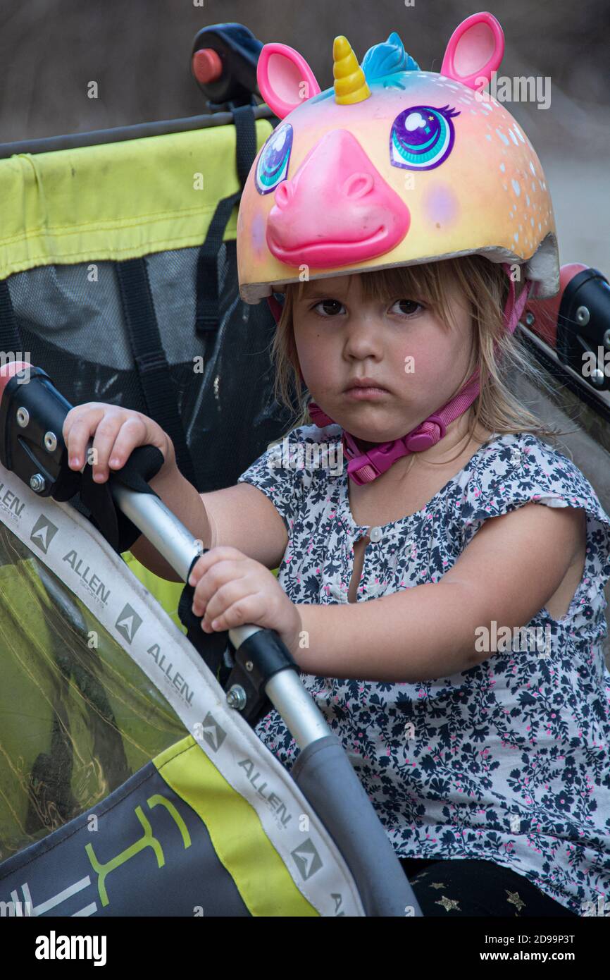 Une petite fille avec un casque unicorn ayant une mauvaise journée au parc. Banque D'Images