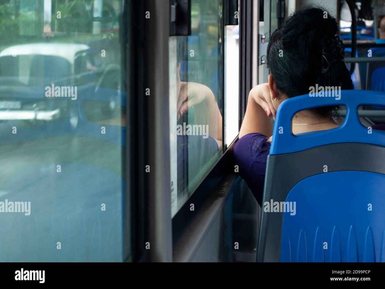 Vue arrière d'une femme assise dans un bus la fenêtre et la pensée seule Banque D'Images
