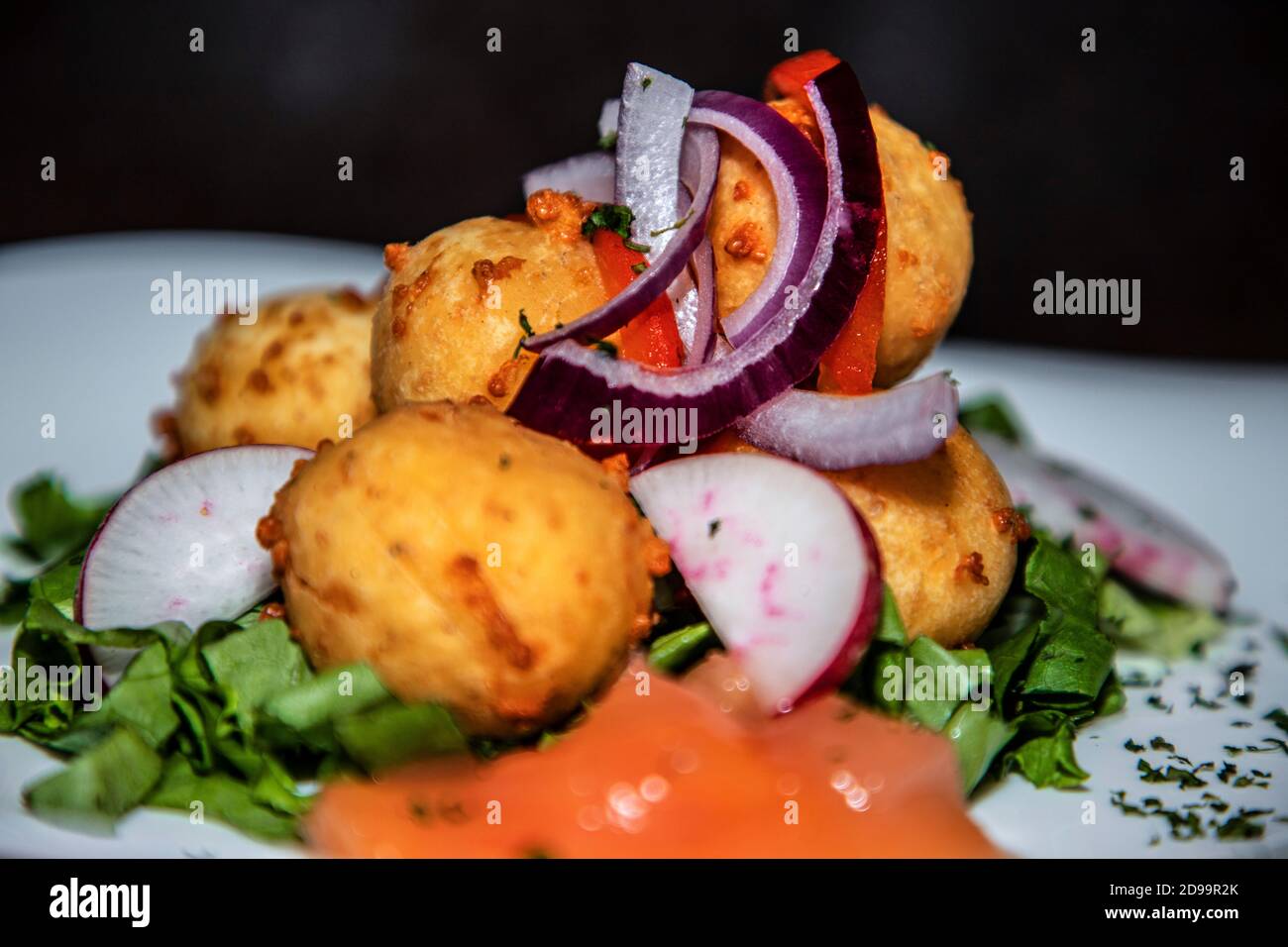 Beaucoup de boules farcies de fromage avec des légumes et de la sauce autour Banque D'Images