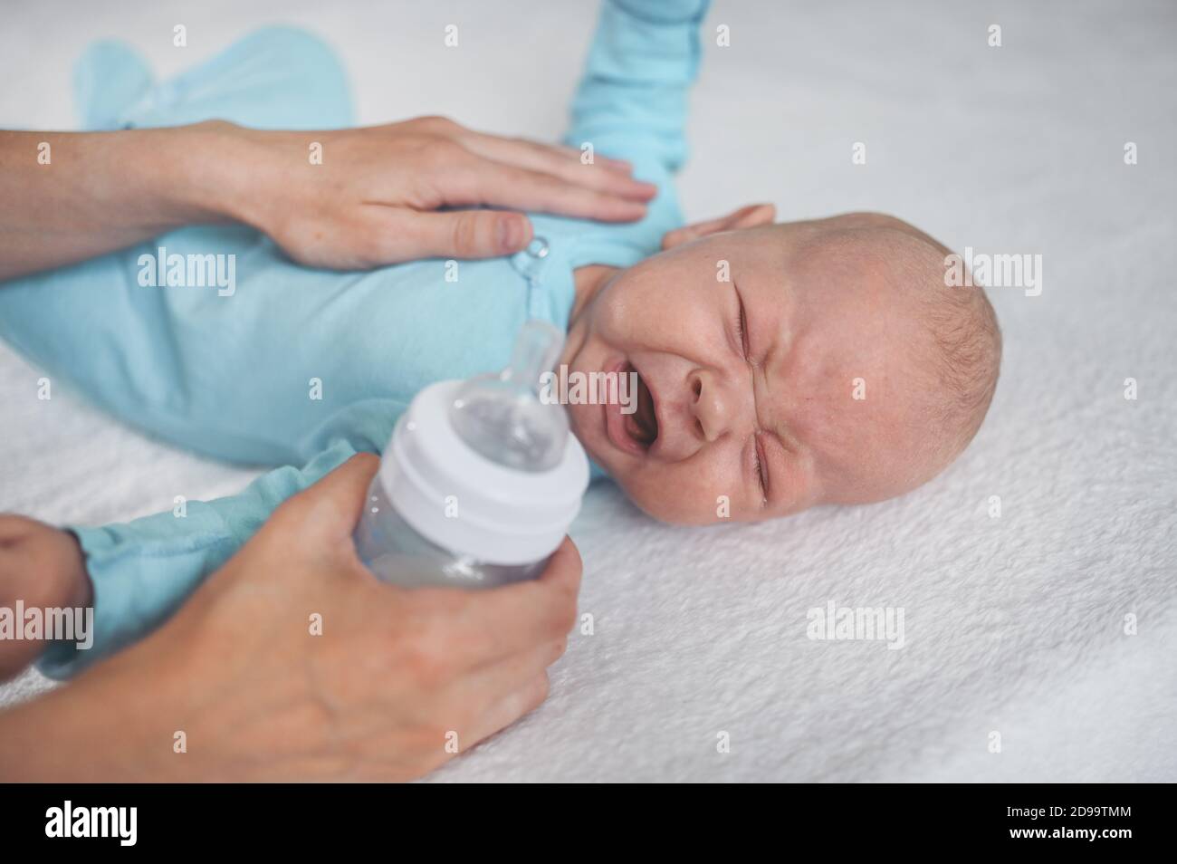Adorable Nouveau Ne En Pleurs Emotifs Pose Sur Le Lit Avec Une Bouteille De Lait Expressions Du Visage De Bebe Modele D Emballage Pour Bebes Enfant En Bonne Sante Concept D Hopital Et Maternite Heureuse