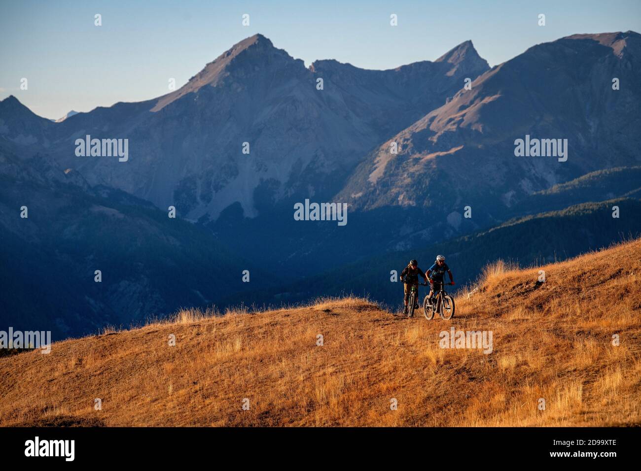 Deux hommes font du vélo au coucher du soleil dans le parc naturel régional Queyras, dans les Hautes-Alpes. VTT, Alpes Banque D'Images