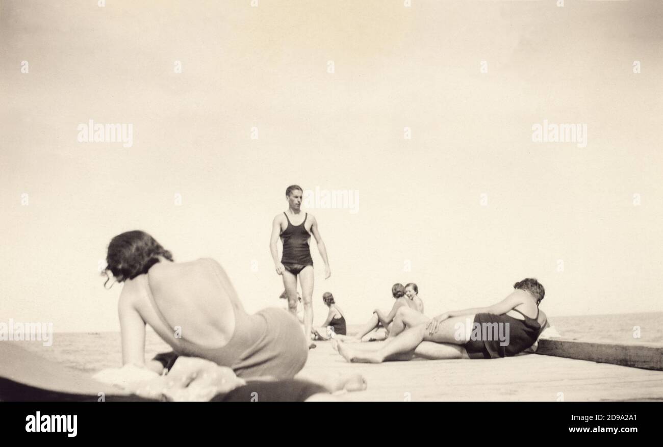 1920' s , Etats-Unis : à la plage - FOTO STORICHE - PHOTOS D'HISTOIRE - - villeggiatura - vacanze - voyage - TURISMO - TURISTA - TURISTI - TOURISME - TOURISTES - mare - mer - PLAGE - SPIAGGIA - bagnanti - plage - nageurs - costume da bagno - maillot de bain - DOMAINE - ÉTÉ - schiena - schiene - dos - bagnante - oddity - gay - homosexuel - homosexualité - omosessualità - LGBT - omosessuale - molo - jetée - canottiera - canotta - abbronzatura - ANNI VENTI - 20's - '20 - MODE - MODA - amis - amici - amico - gambe - jambes --- Archivio GBB Banque D'Images