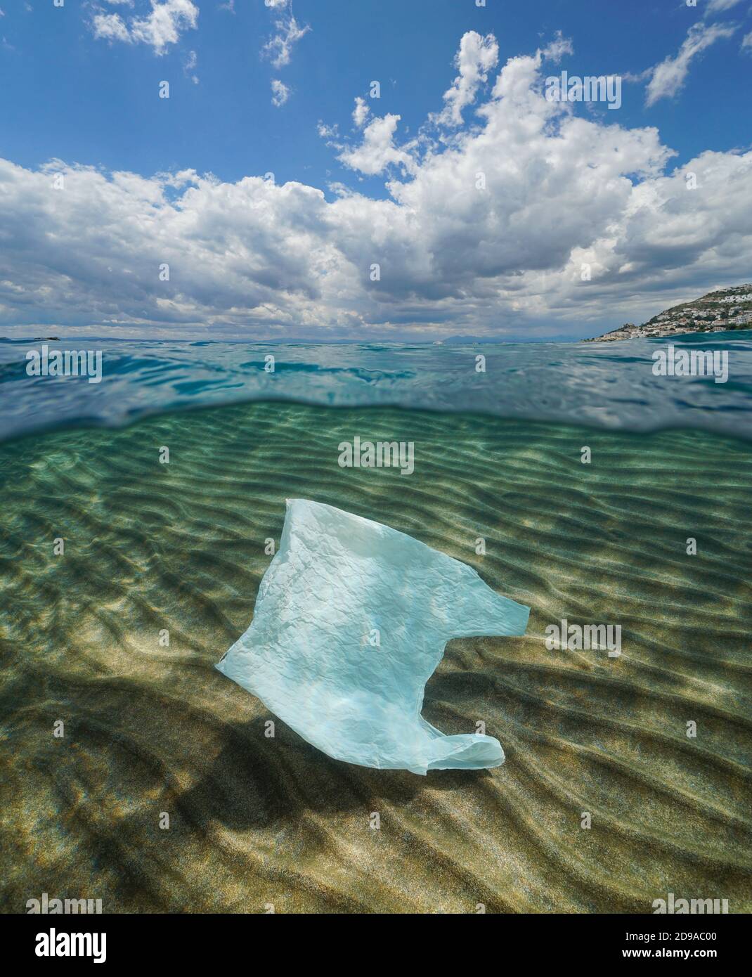 Pollution des déchets de plastique dans l'océan, un sac en plastique sous l'eau et ciel bleu ciel nuageux, vue partagée sur et sous la surface de l'eau Banque D'Images